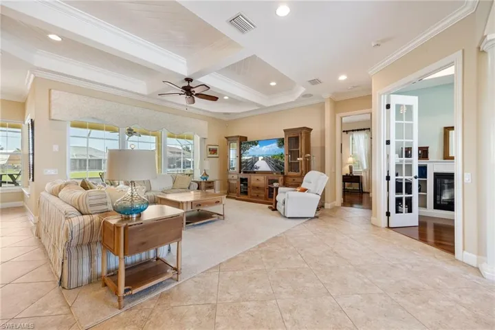 living room with view of den, entrance to primary, and pocket sliders