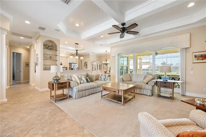 living room with pocket sliders, view of kitchen, and hallway to bedrooms and bathrooms