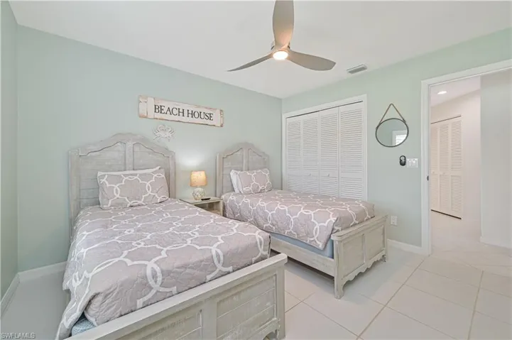 Tiled bedroom with a closet and ceiling fan