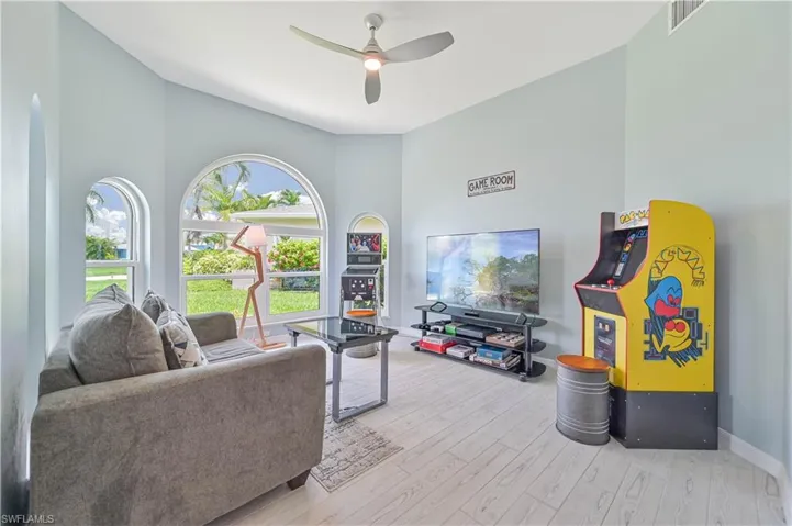Living room with hardwood / wood-style flooring, a high ceiling, and ceiling fan