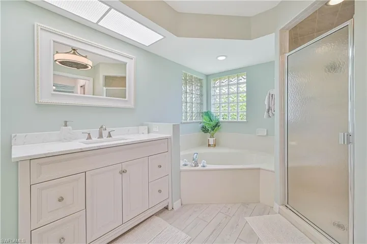Bathroom with plus walk in shower, vanity, and tile patterned flooring