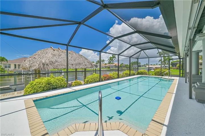 View of swimming pool featuring a water view and glass enclosure