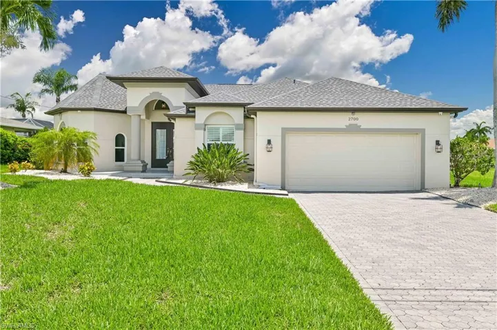 View of front of house with a garage and a front yard