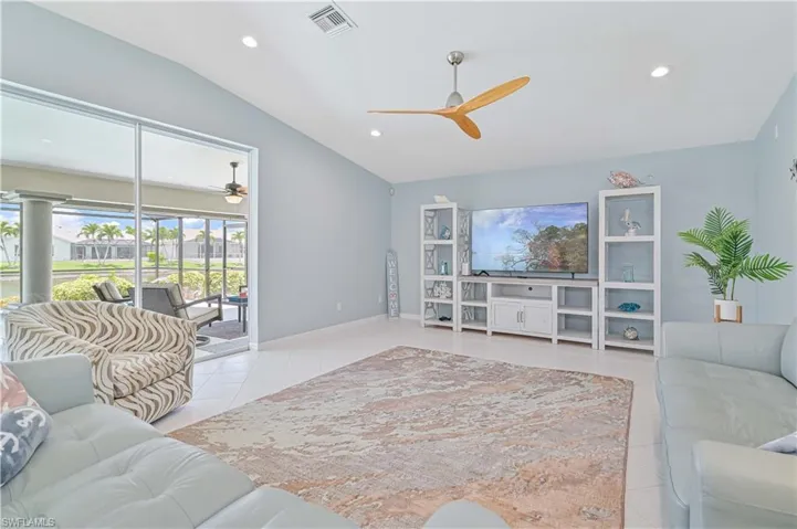 Tiled living room featuring ceiling fan and lofted ceiling