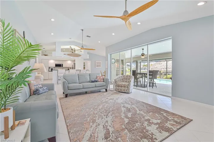 Tiled living room featuring vaulted ceiling and ceiling fan