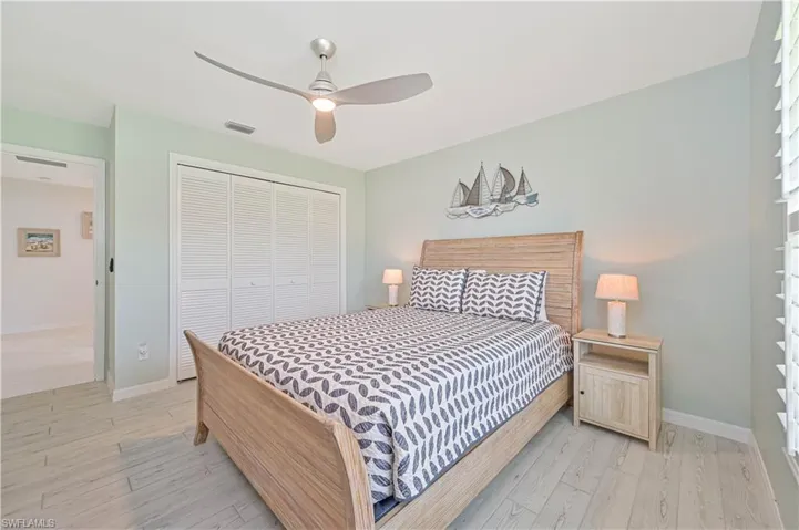 Bedroom with a closet, light wood-type flooring, and ceiling fan