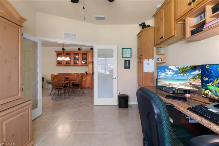Tiled office featuring ceiling fan and french doors