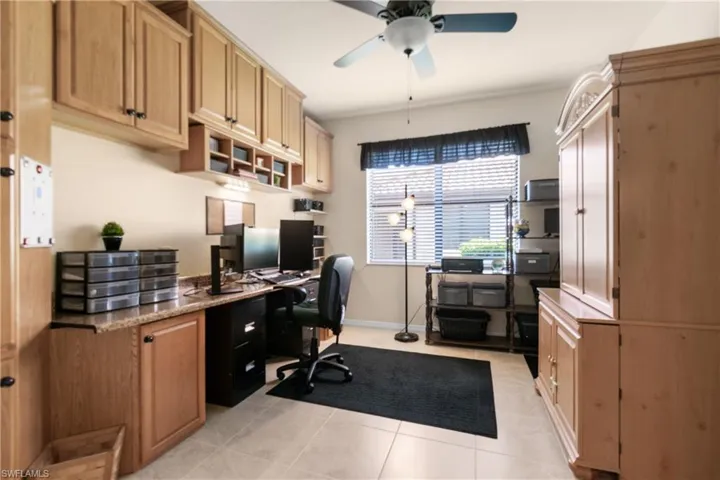 Home office with light tile patterned floors and ceiling fan