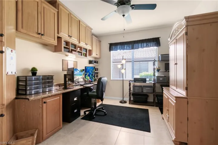 Office featuring light tile patterned floors, built in desk, and ceiling fan