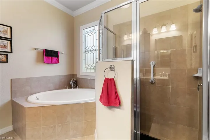 Bathroom featuring crown molding, tile patterned flooring, and shower with separate bathtub