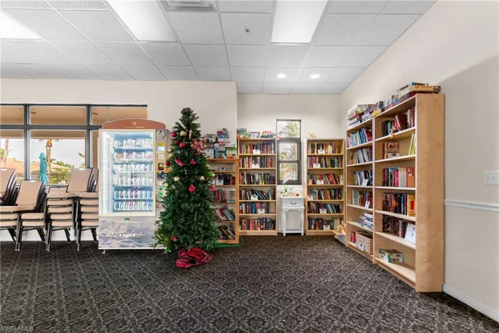 Misc room with dark colored carpet and a paneled ceiling