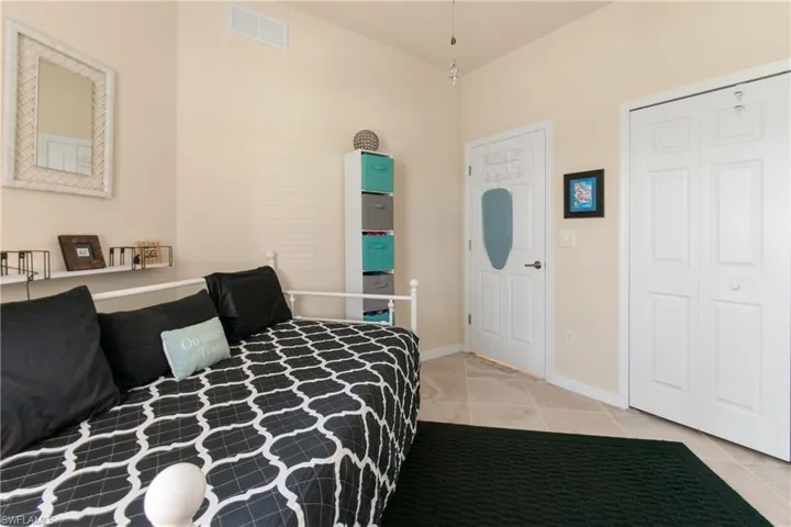 Tiled bedroom featuring a closet