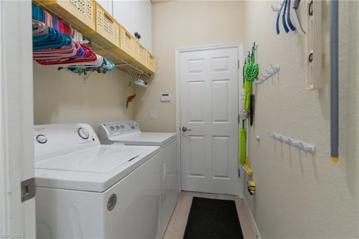 Washroom featuring independent washer and dryer and light tile patterned floors