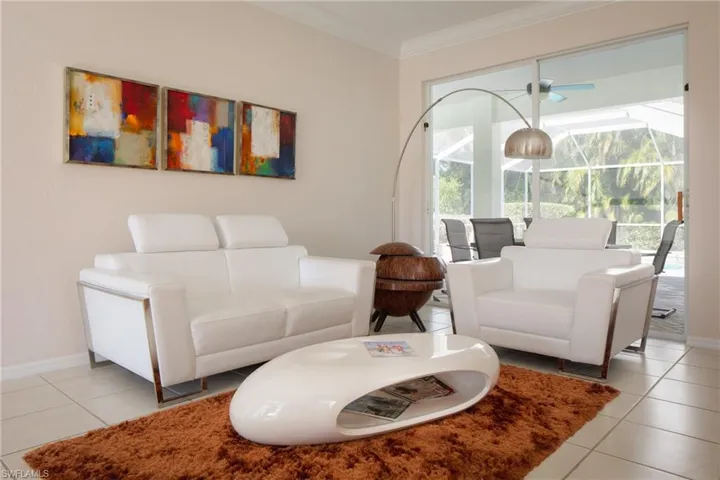 Tiled living room featuring crown molding, a wealth of natural light, and ceiling fan