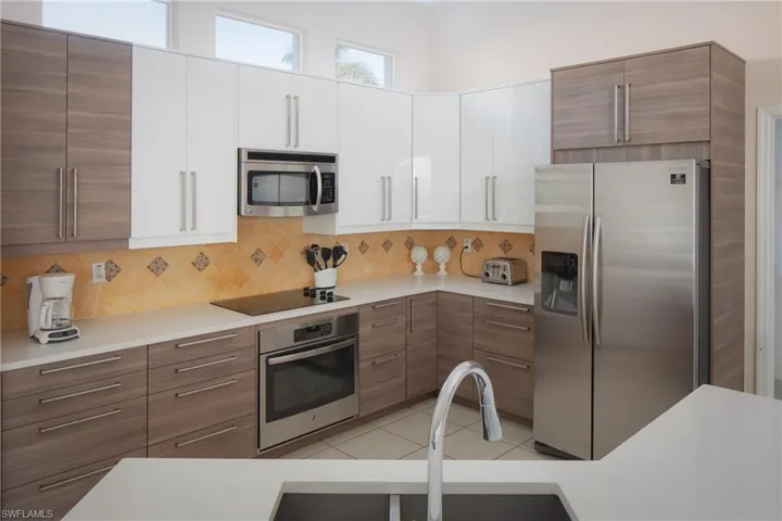Kitchen featuring white cabinetry, appliances with stainless steel finishes, tasteful backsplash, and light tile patterned floors