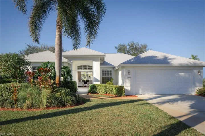 View of front facade featuring a garage and a front yard