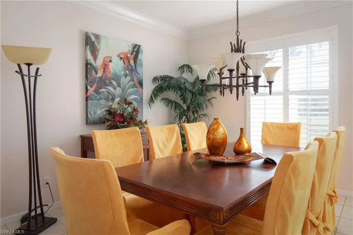 Dining room with an inviting chandelier, crown molding, and light tile patterned floors