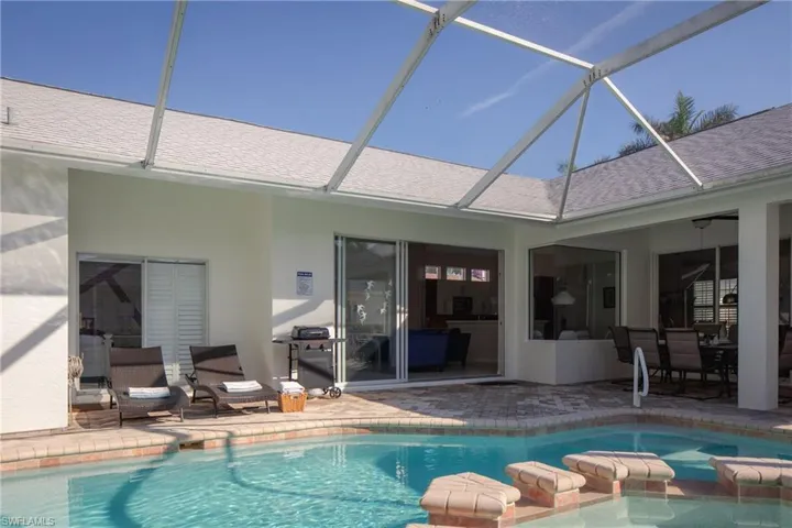 View of pool featuring a patio and glass enclosure