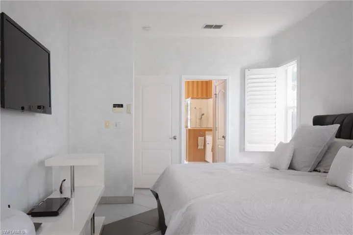 Tiled bedroom featuring ensuite bath