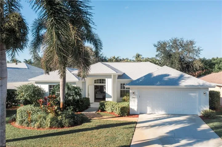 Ranch-style home featuring a garage and a front lawn