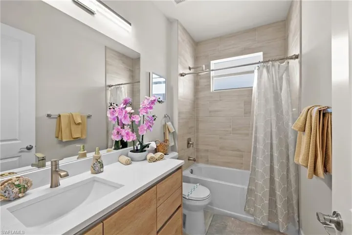 Bathroom with shower / bath combination with curtain and vanity
