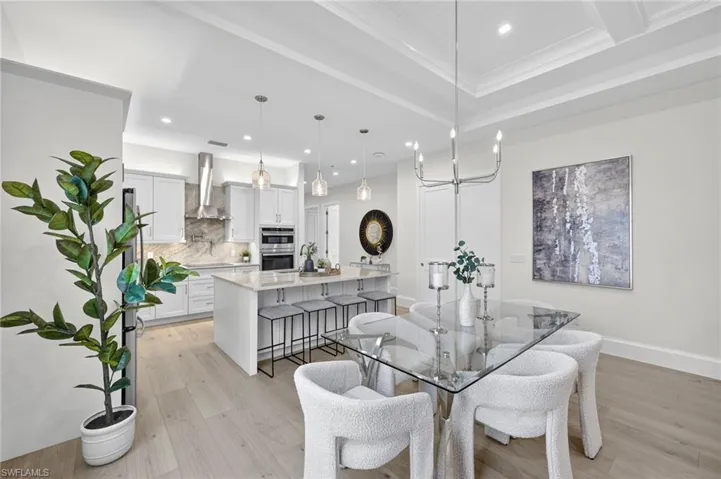 Dining room featuring light wood finished floors, recessed lighting, and ornamental molding
