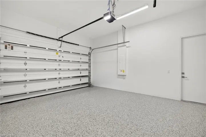 Garage featuring a garage door opener and electric panel