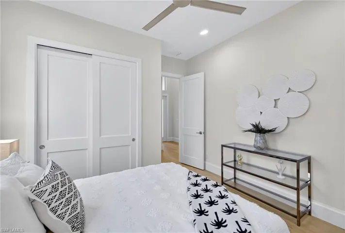 Bedroom with light wood-style floors, ceiling fan, recessed lighting, and a closet