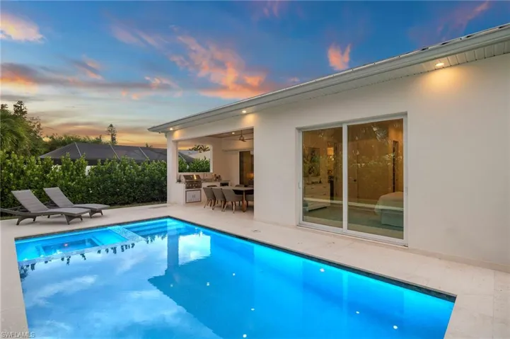 View of swimming pool with a patio area, a pool with connected hot tub, and an outdoor kitchen