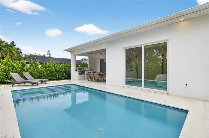 View of pool featuring a patio area, a pool with connected hot tub, ceiling fan, and area for grilling