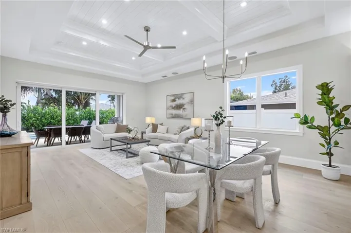 Dining area with light wood finished floors, ceiling fan, a chandelier, a wood ceiling with exposed beams, and recessed lighting
