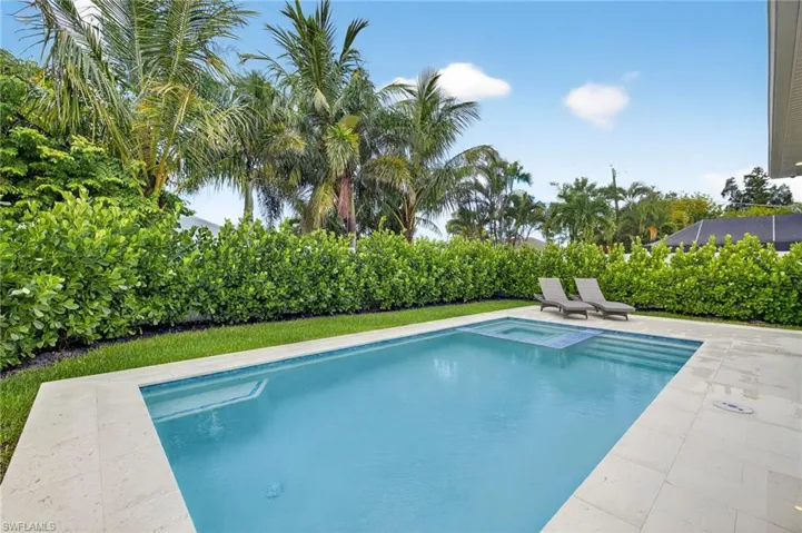 View of pool with a patio area and a pool with connected hot tub