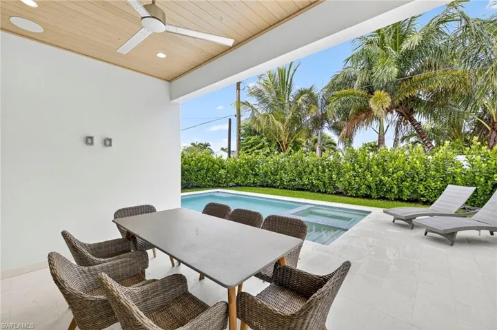 View of pool with a patio area, a ceiling fan, outdoor dining area, and a pool with connected hot tub