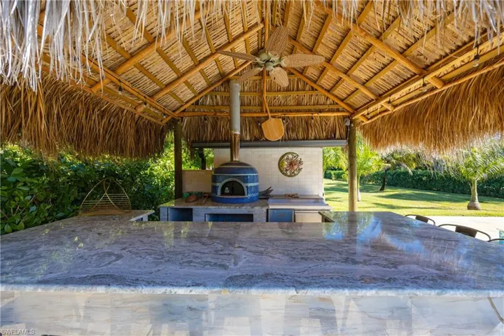 View of patio with ceiling fan and area for grilling