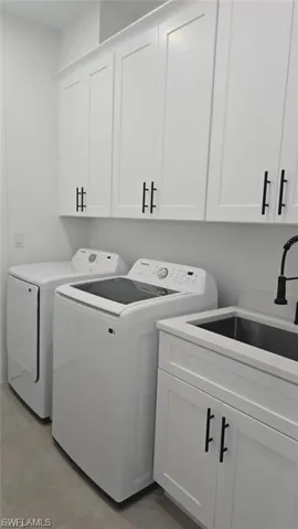 Laundry area with washer and clothes dryer and cabinet space