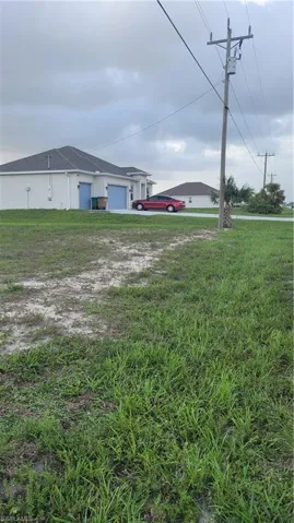 View of green lawn featuring an attached garage