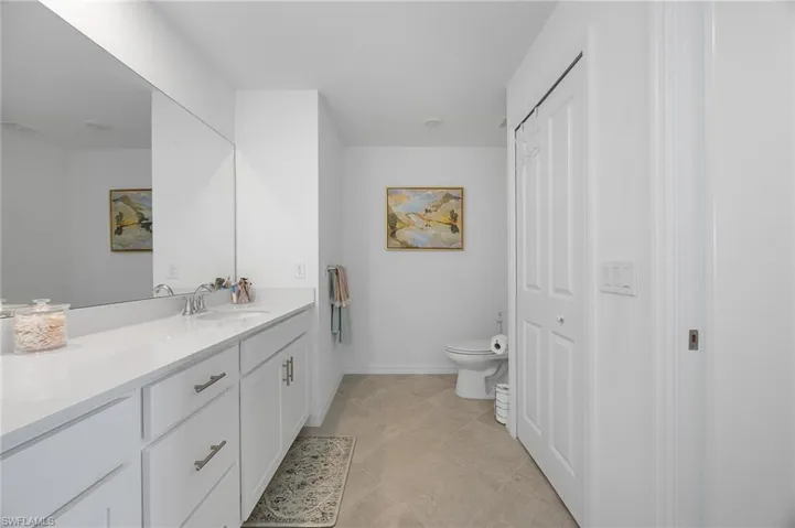 Full bathroom with vanity, a closet, and light tile patterned floors