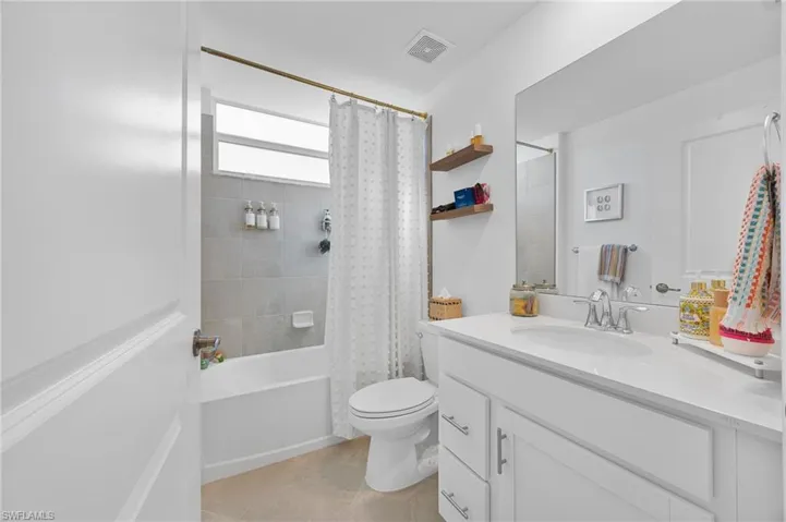 Full bath with shower / bath combination with curtain and vanity