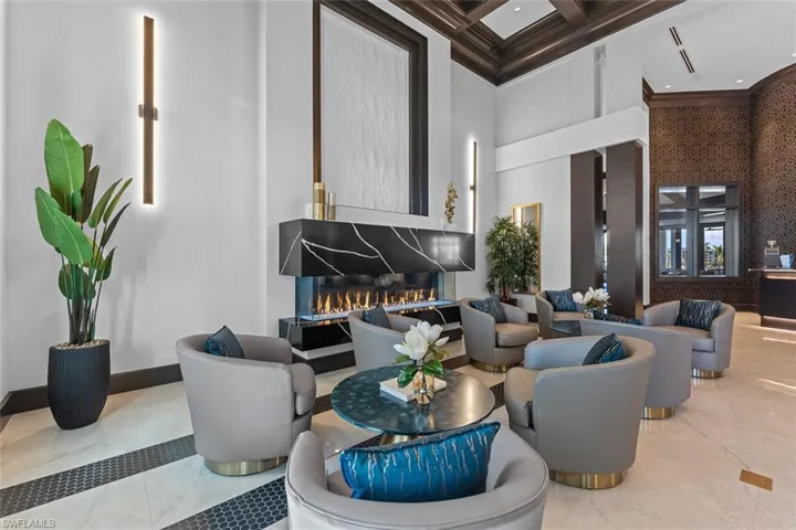 Lobby featuring a towering ceiling, coffered ceiling, ornamental molding, and wallpapered walls