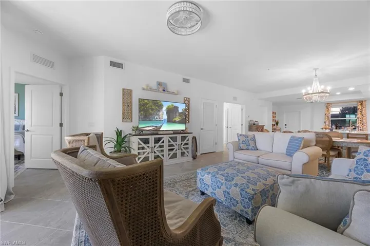 Tiled living area featuring a chandelier and plenty of natural light