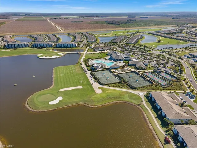 Aerial perspective of suburban area featuring a golf course and a large body of water