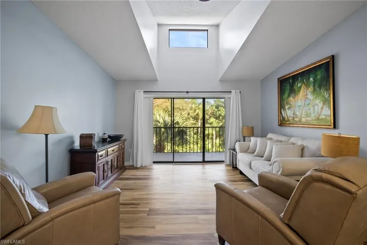 Living room featuring a textured ceiling, light hardwood / wood-style floors, and a healthy amount of sunlight