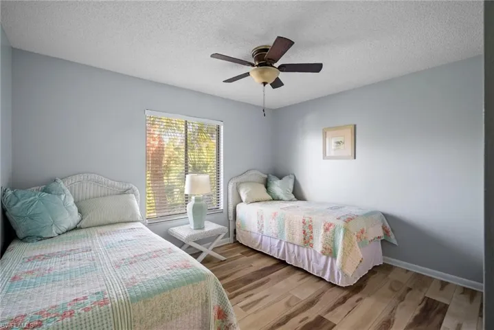 Bedroom featuring ceiling fan, a textured ceiling, and wood-type flooring