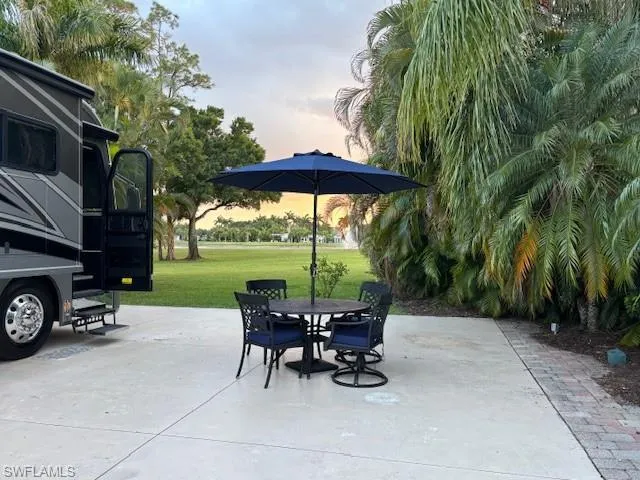 Patio terrace at dusk with a yard and outdoor dining area