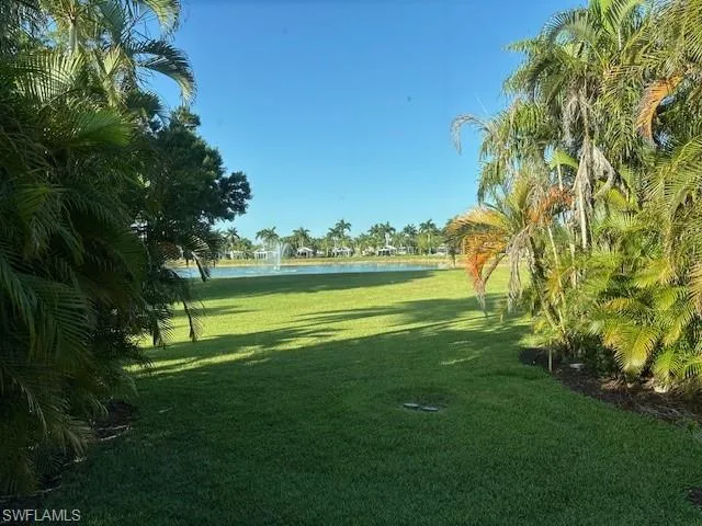 Surrounding community with a water view and a yard