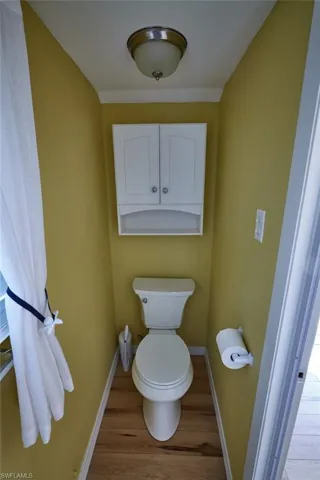 Bathroom featuring wood-type flooring and toilet