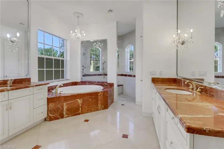 Gorgeous custom marble counters and tub, with huge shower overlooking private garden area.