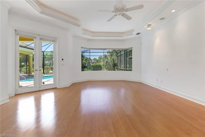 Primary suite on separate wing of the house, double doors leading to pool area and large wall of windows for beautiful views of pool and lake.