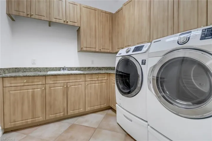 Huge laundry room with sink and tons of storage.
