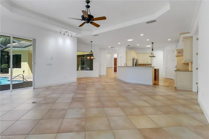 Open kitchen, living and dining space with pool views.